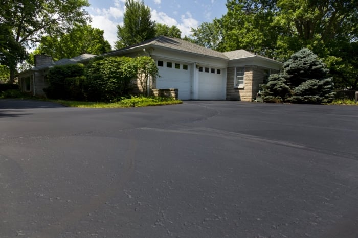 sealed asphalt driveway with home in background